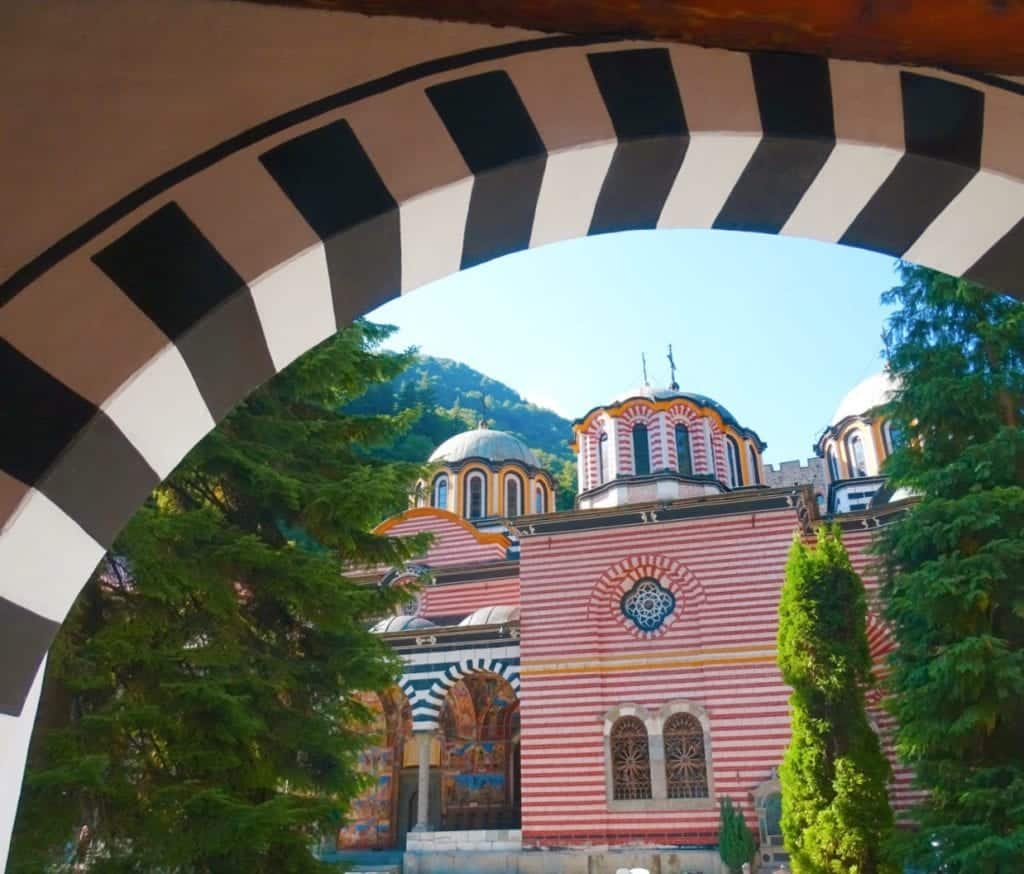 Red and yellow striped Rila Monastery through a doorway