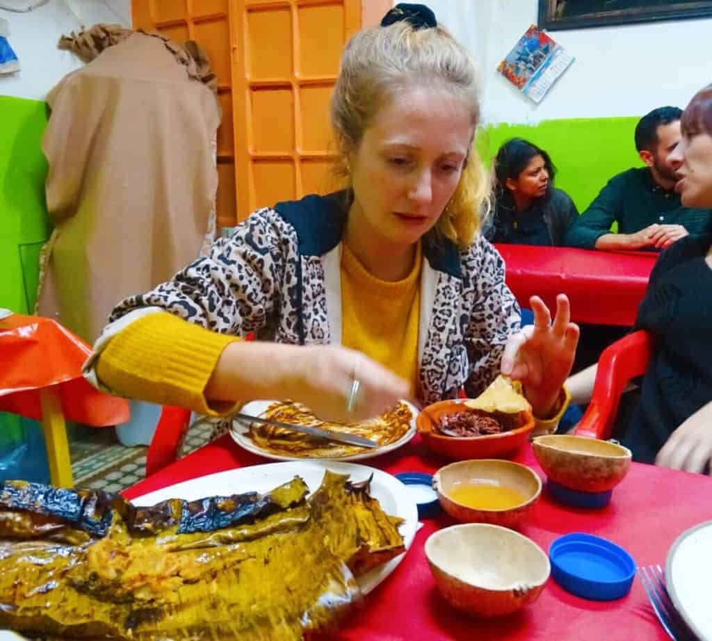 Girl looking hesitant eating grasshoppers