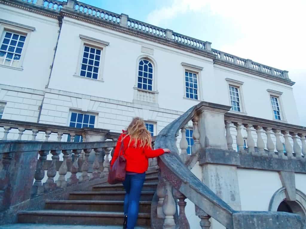 Girl in red coat walking up steps to the Queens House Greenwich 