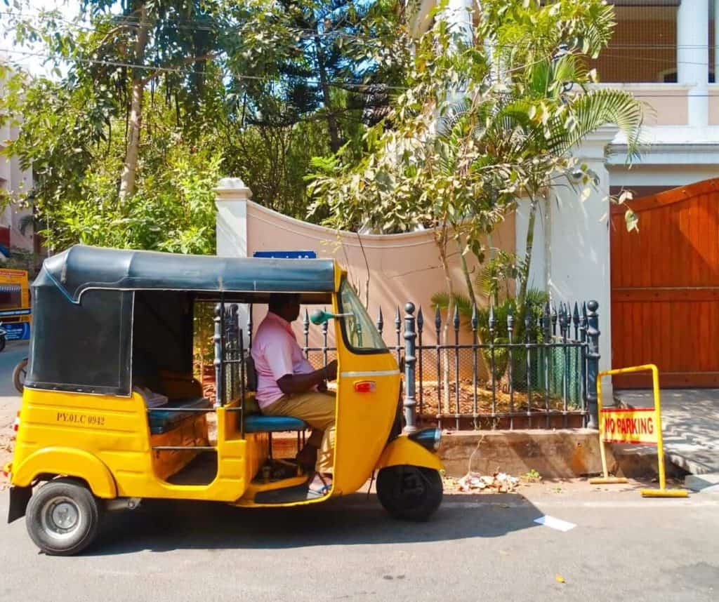 Yellow tuk-tuk driving through Pondicherry 