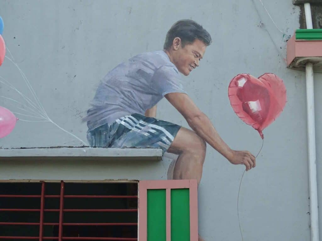 Man with balloon street art Tam Thanh Mural Village