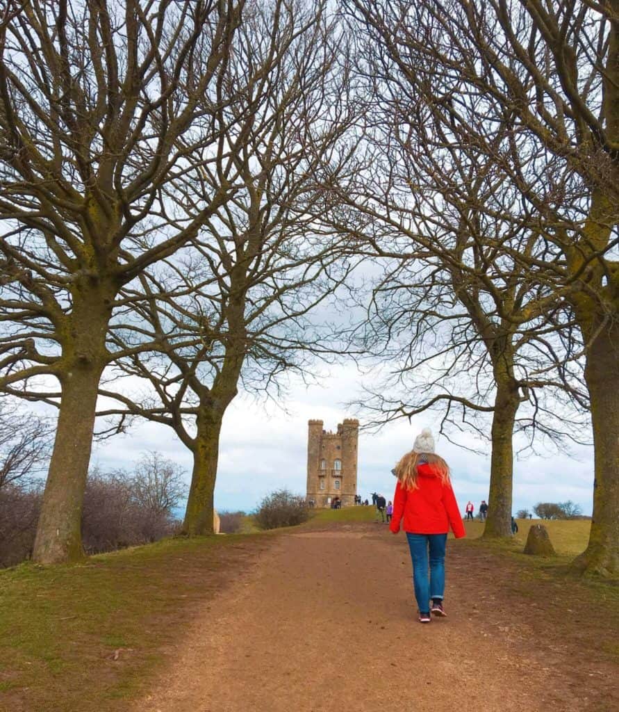 Girl in red coat walking towards Broadway tower 