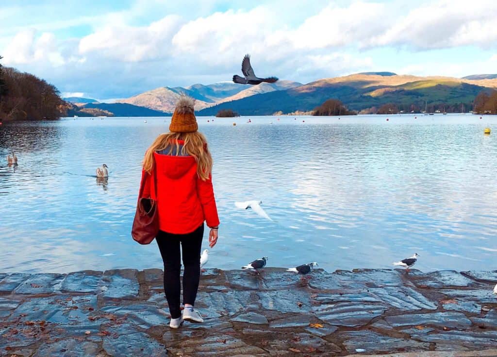 Girl in red jacket beside lake Windermere