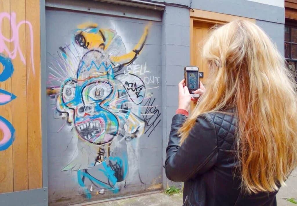 Taking photo of street art shoreditch 