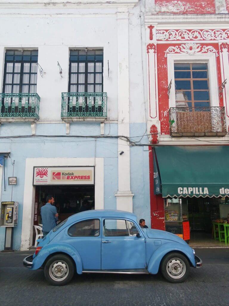 top places to visit in puebla mexico Blue Beatle car beside busy Puebla Street