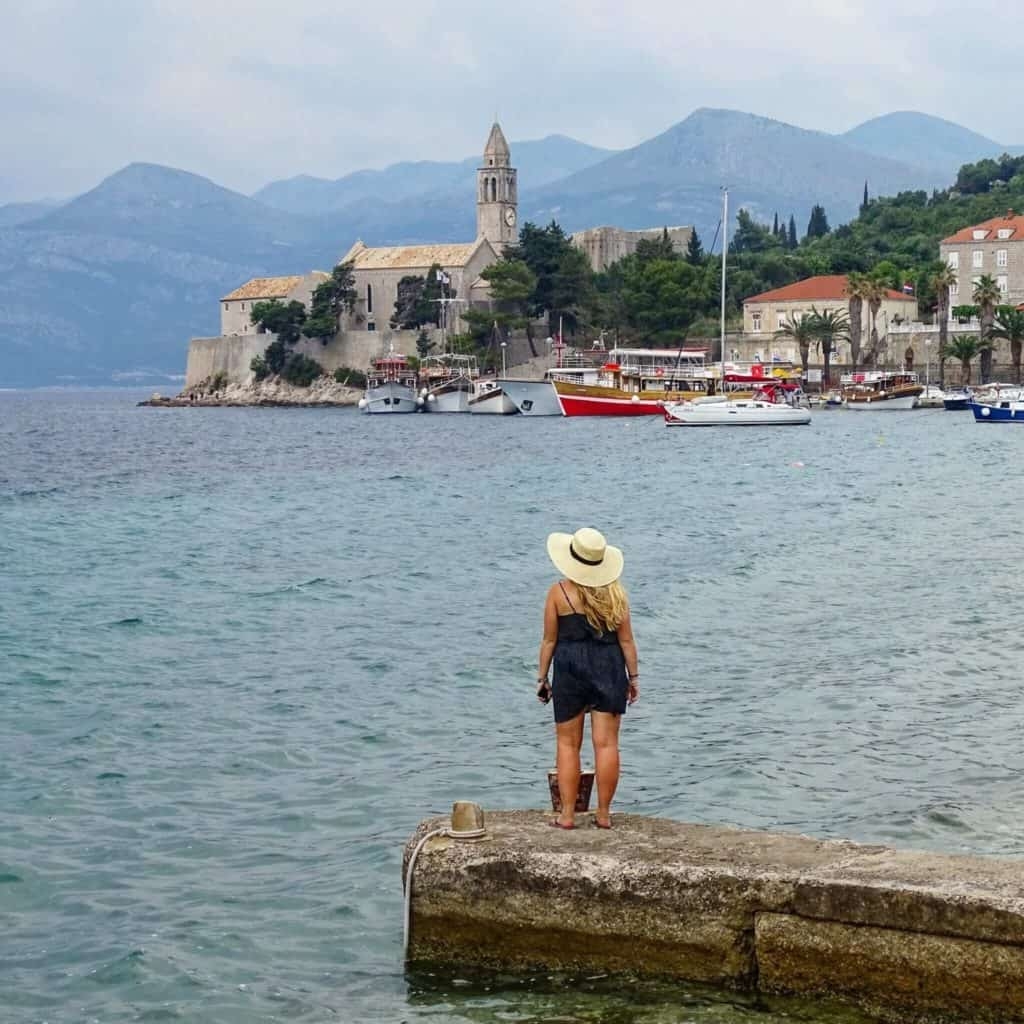 Girl looking over Kolocep harbour Croatia